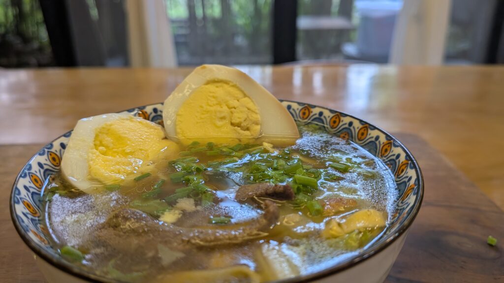 Bowl of soup with eggs and herbs