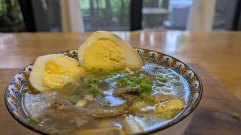Bowl of soup with eggs and herbs